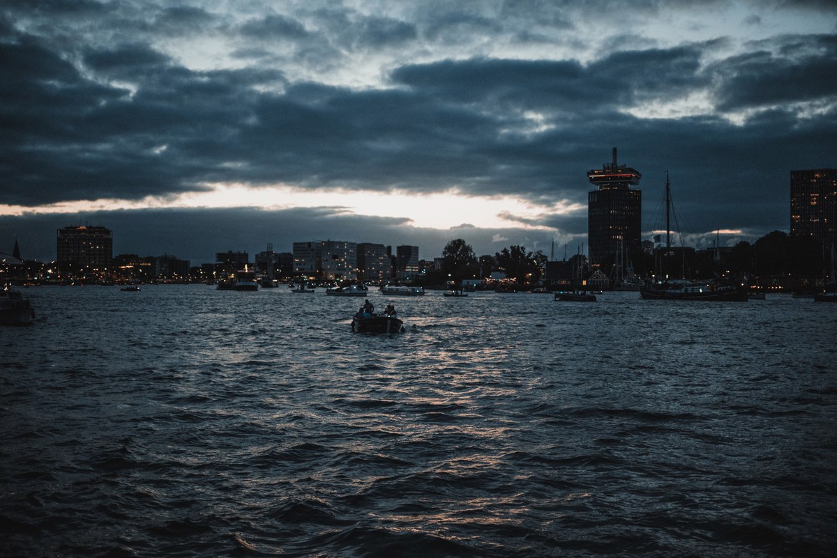 De avond tijdens SAIL Amsterdam, met een boot op het water