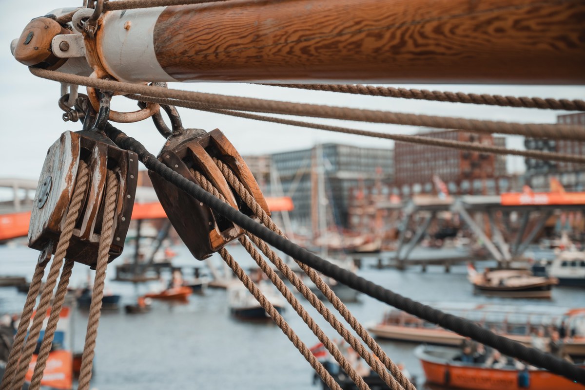 Een detail van de Bark Europa, terwijl bootjes langsvaren tijdens SAIL Amsterdam