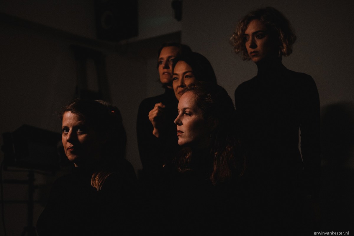Lavinia Meijer staat met de zangeressen van Wishful Singing in een spot.