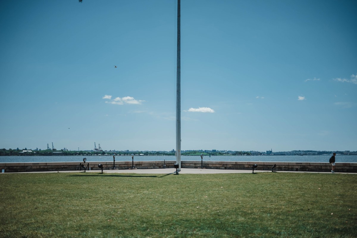 Een vlaggenmast op Ellis Island, met een groen veld.