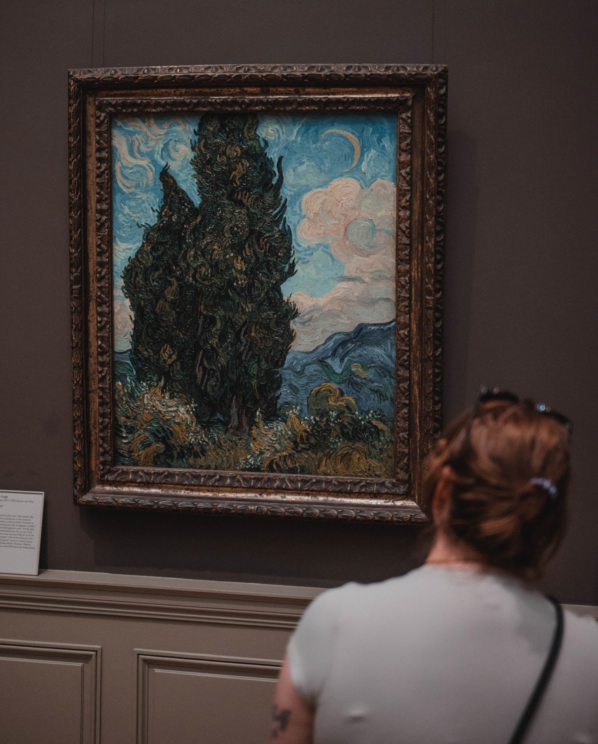 Een schilderij met een vrouw die ernaar kijkt