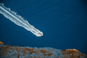 Een speedboot scheert over het blauwe water