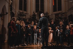 Dirigent met zangers en kinderen