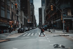 Een rustige straat in New York. Er loopt een voetganger voorbij.