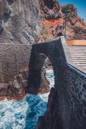 Een brug over wild water aan de kust