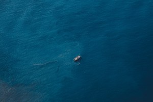 Een enkele boot in het midden van de blauwe zee