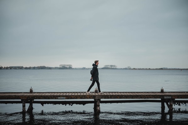 Tim loopt over een vlonder, achter hem het meer bij Veere