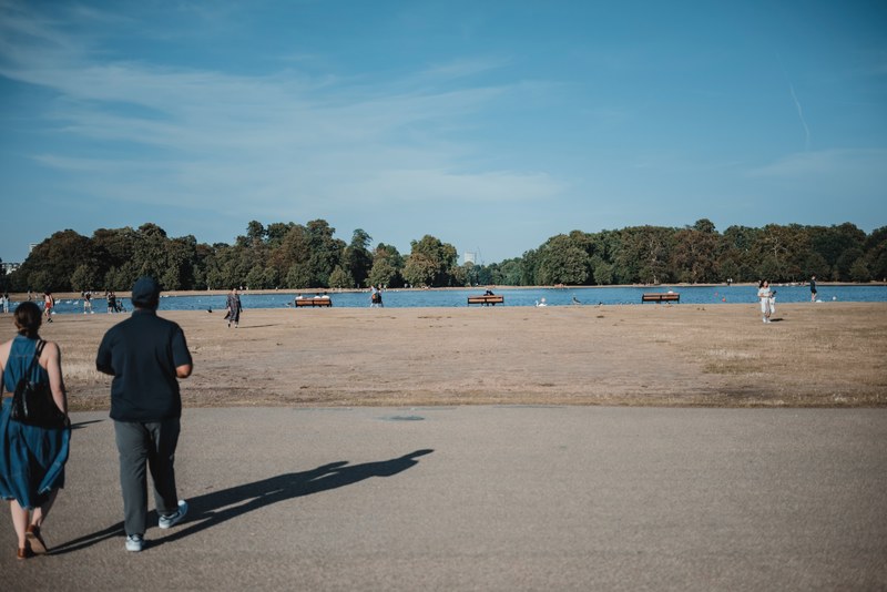 Een koppel loopt naar een meer in Hyde Park, Londen, op een mooie zomeravond.