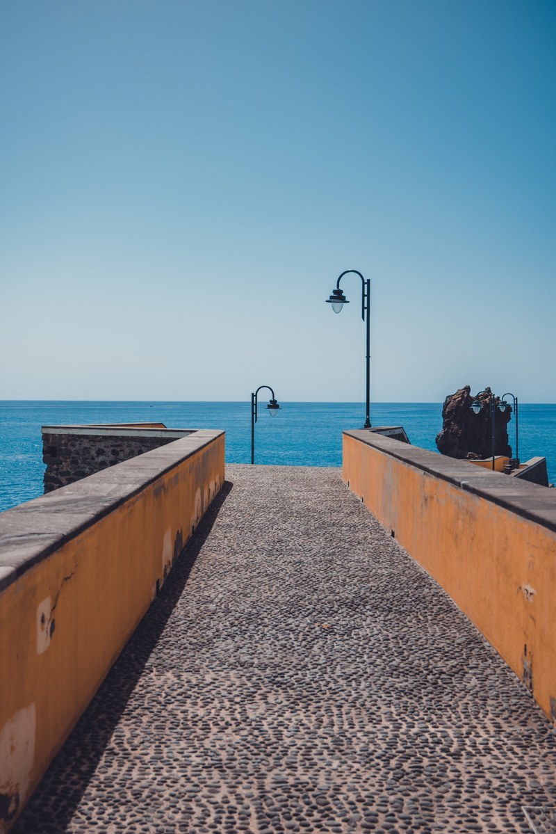 Een klassieke pier met daarachter het blauwe water