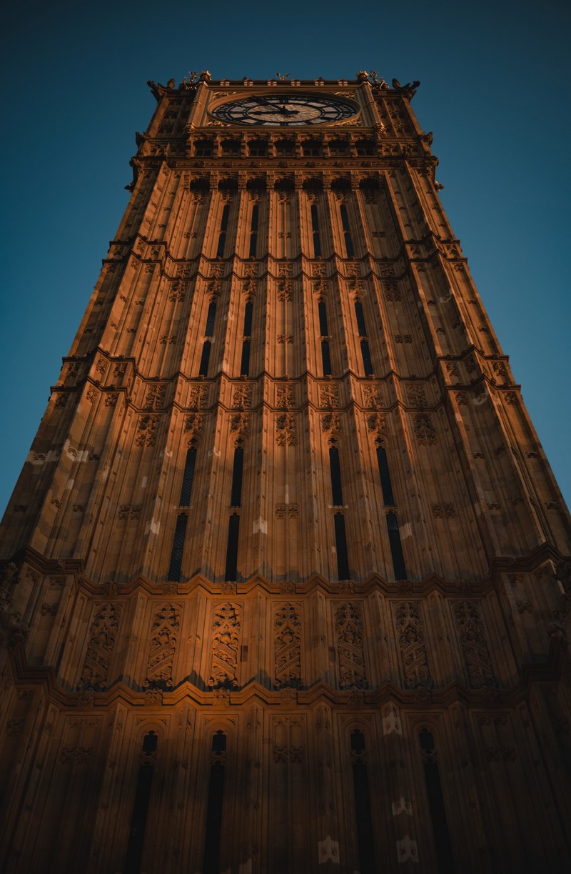 De Big Ben in Londen, van onderaf met het zonlicht erop, op een zomeravond.