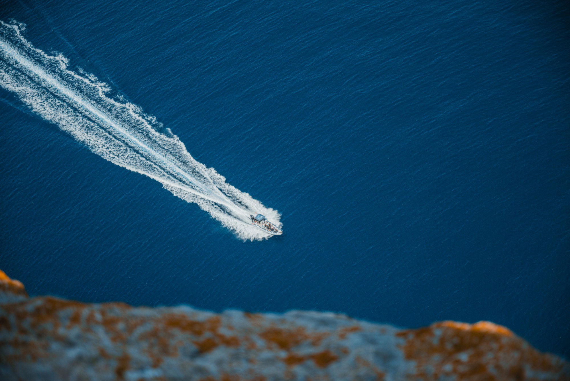 Een speedboot scheert over het blauwe water