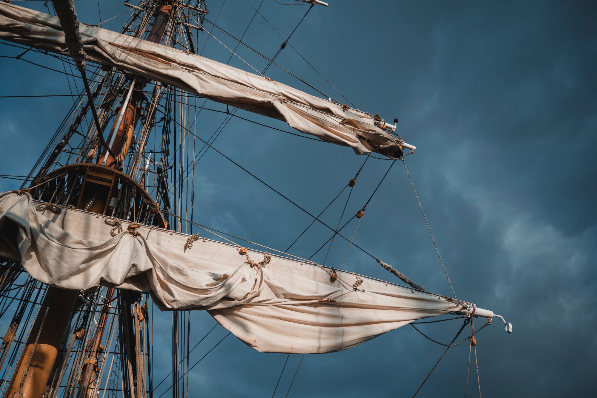 De mast van de Bark Europa in de zon, tegen een achtergrond van wolken