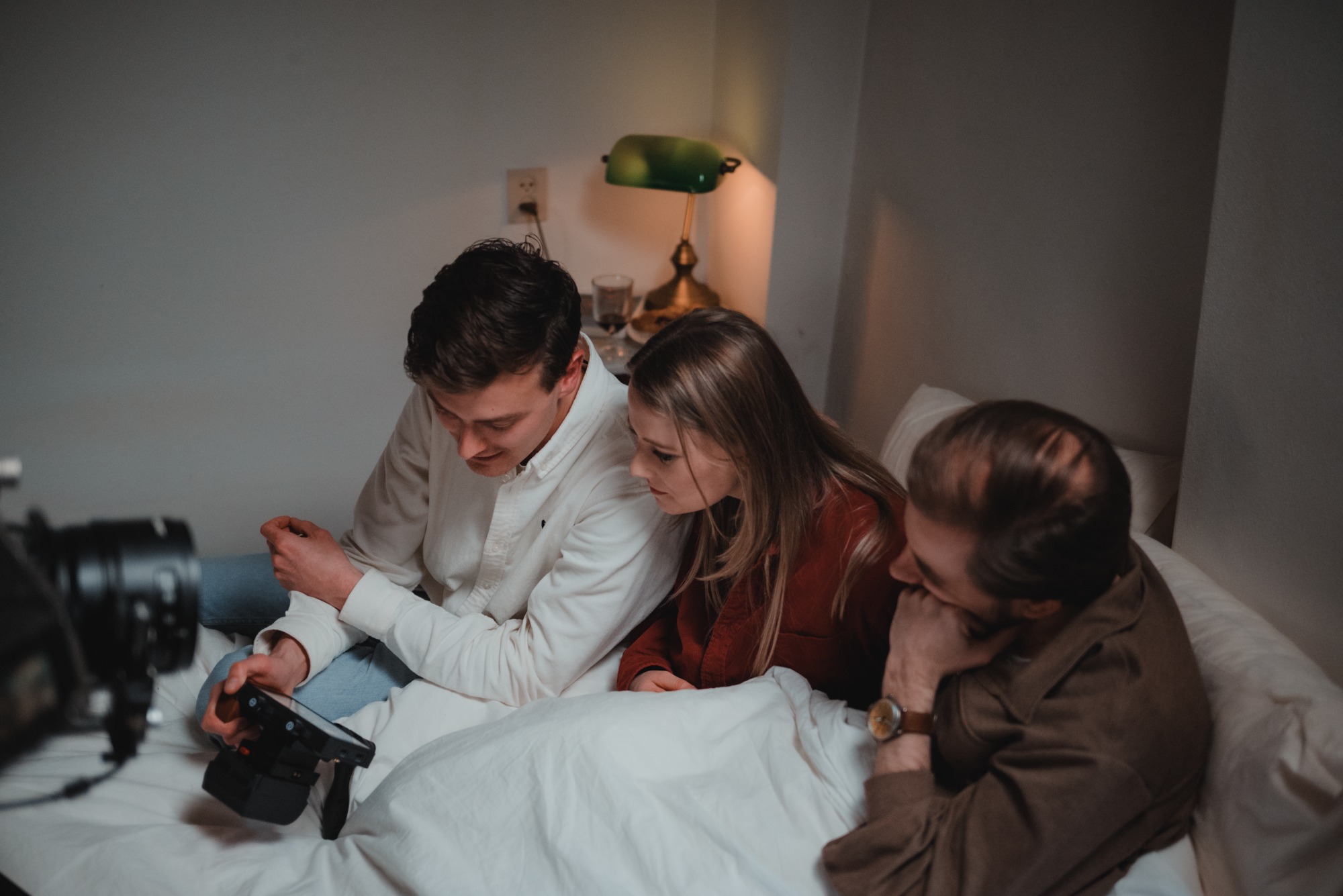 Twee acteurs in bed bij De Verdwenen Nacht, terwijl de regisseur ze mee laat kijken.